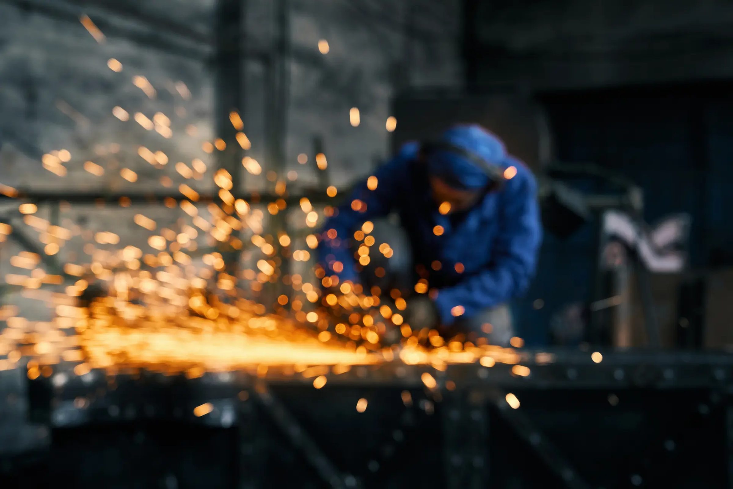 Sparks flying as a fabricator grinds carbon steel on the shop floor at Walco Fabricating