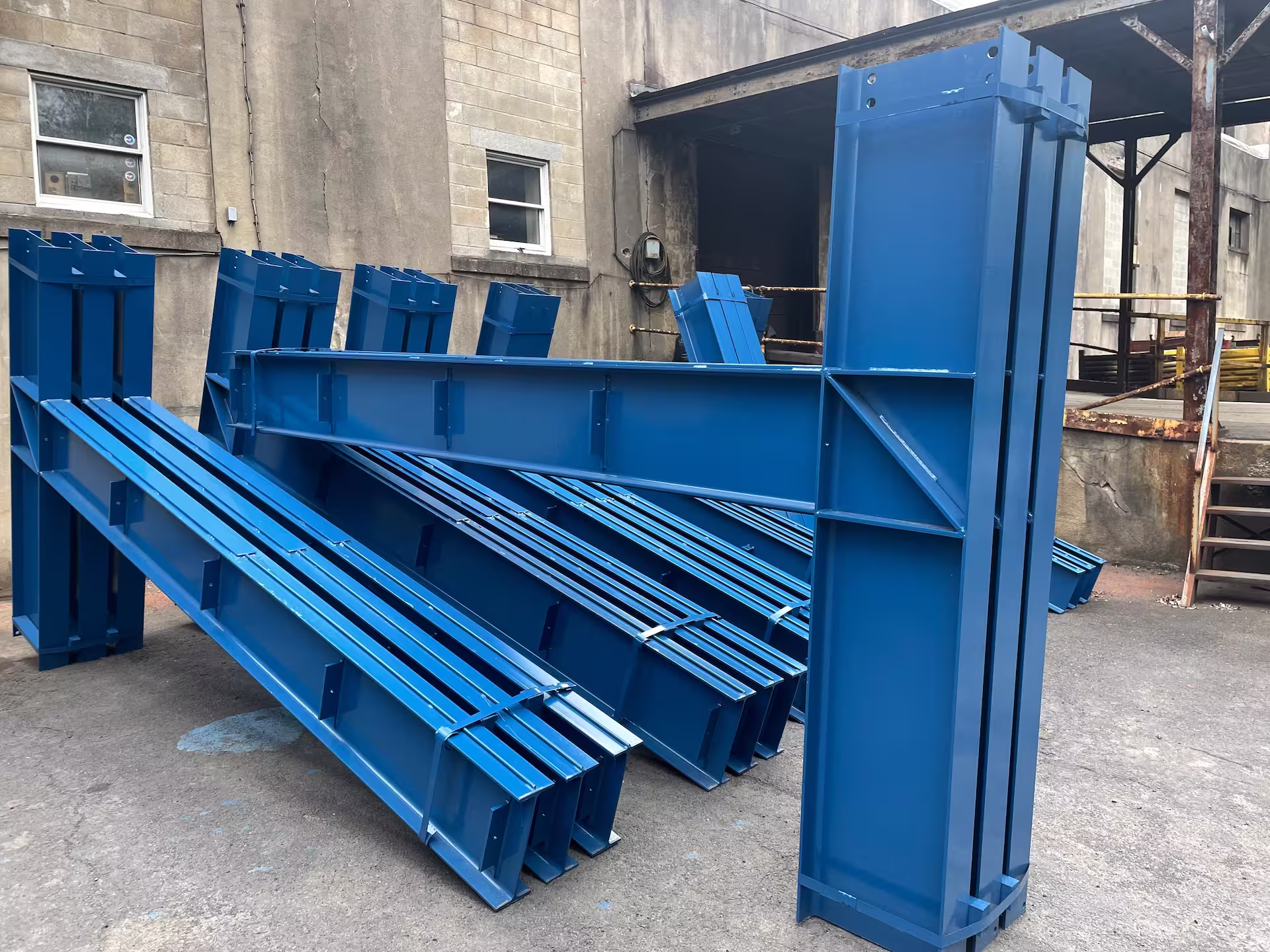 Fabricated steel staged beside the industrial paint dipping line inside the Walco shop
