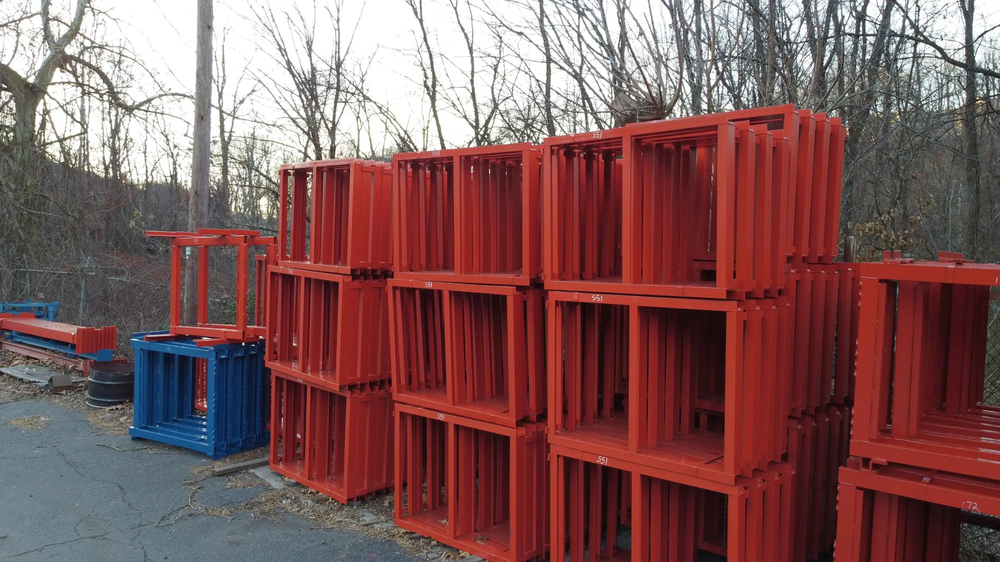 Finished red steel frames stacked outside, staged for shipment
